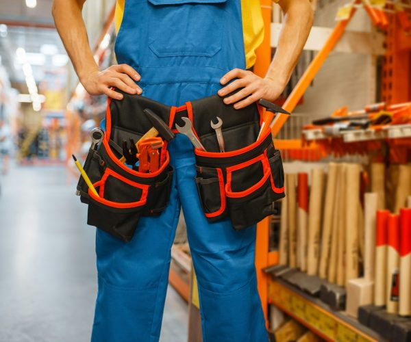Male builder trying on tool belt in hardware store